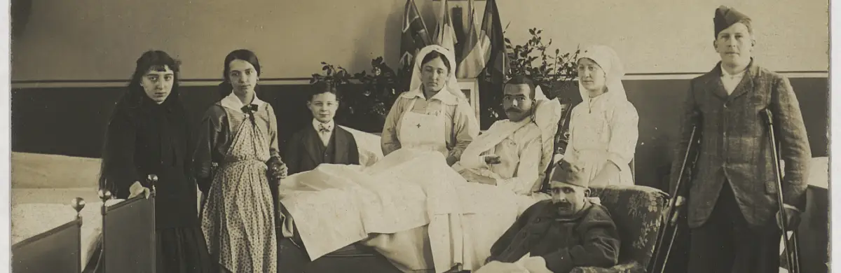 Picture of WWI infirmary patient surrounded by wellwishers